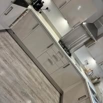 A pale kitchen with a cleaned worktop and range hood.
